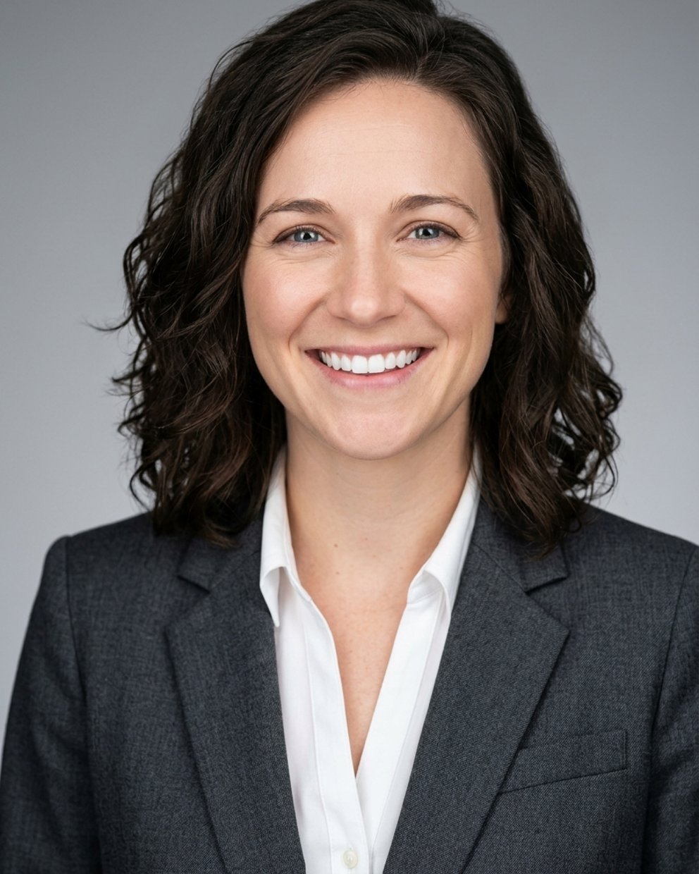 Grey studio headshot, charcoal suit